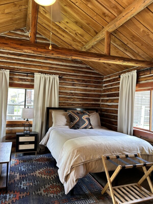 A bedroom in Alpine Standard Cabin #10 with a bed and a bedside table.