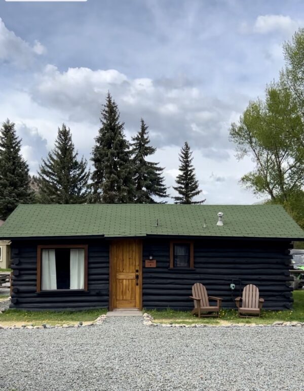 An Alpine Standard Cabin #2 with two chairs and a gravel driveway.