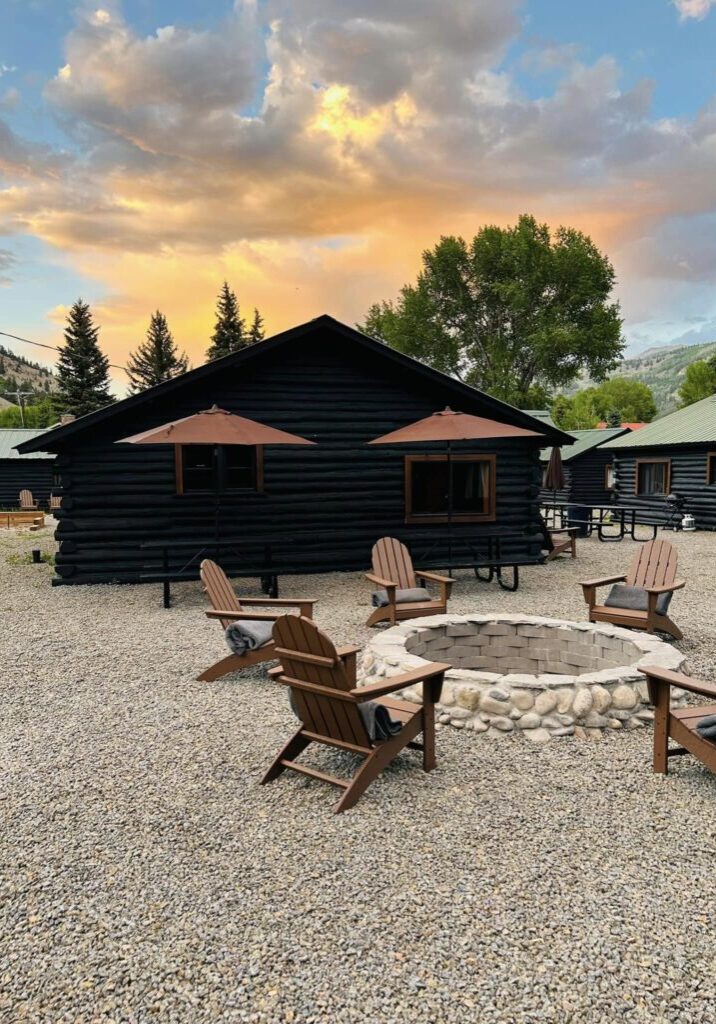 An Alpine Deluxe Cabin with a fire pit in front of it.